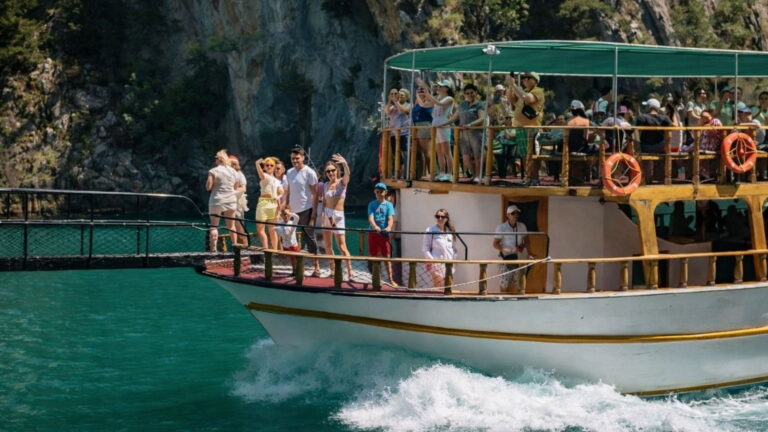 Boat cruising the emerald waters of Green Canyon near Side