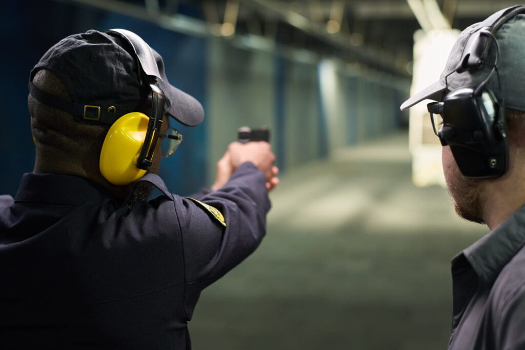 Professional certified instructor guiding tourists at Side indoor shooting range with safety briefing