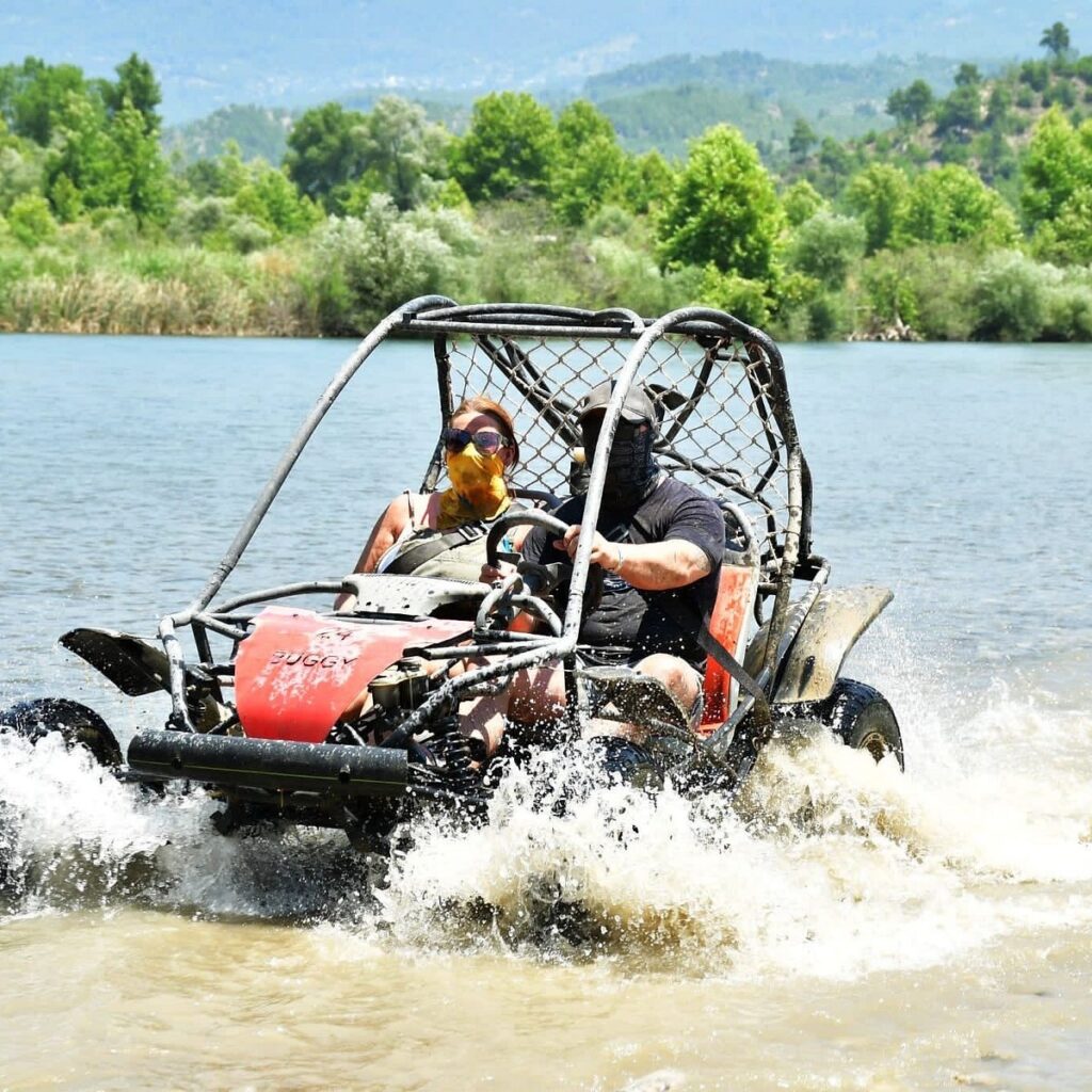 Tour group taking a refreshing swimming break in a natural river pool during a Side Antalya buggy safari adventure.