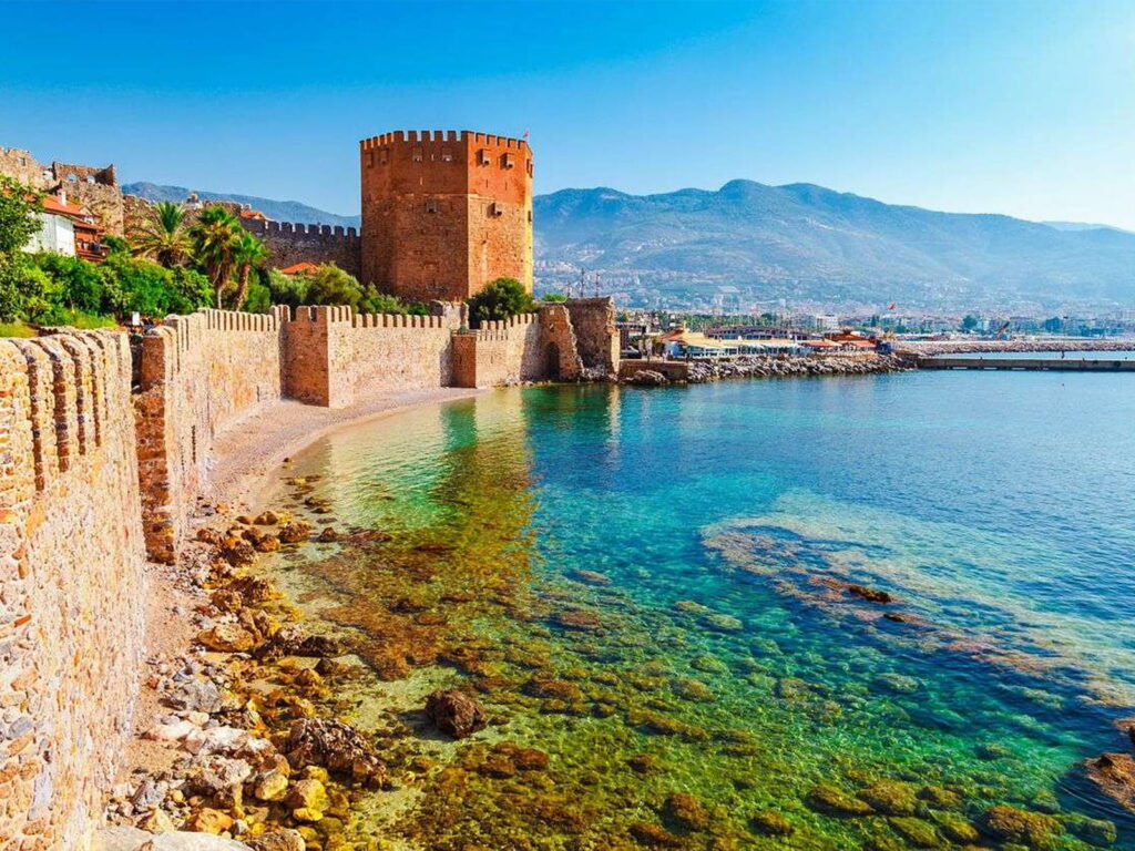 Octagonal red brick tower standing beside the ancient Seljuk naval shipyard at Alanya harbor