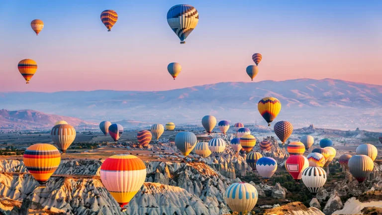 Hot air balloons flying over fairy chimneys in Göreme Cappadocia at sunrise