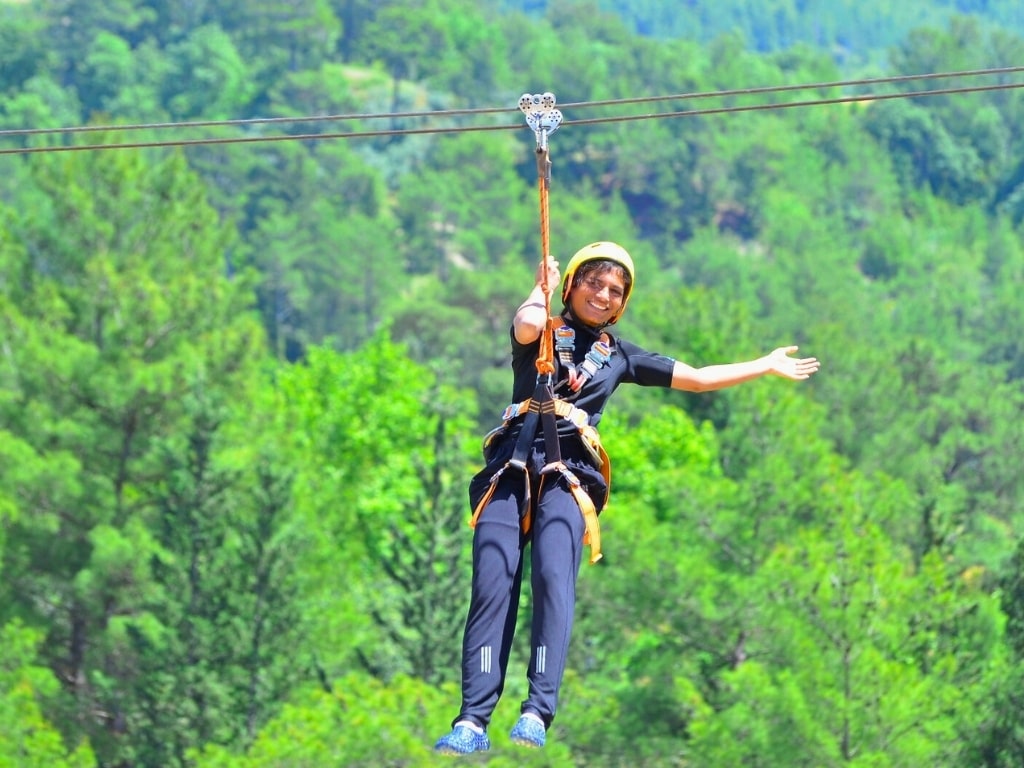 Rider crossing the 700-metre zipline over Köprülü Canyon near Side, Antalya, with the Köprüçay River, canyon valley and Taurus Mountains below
