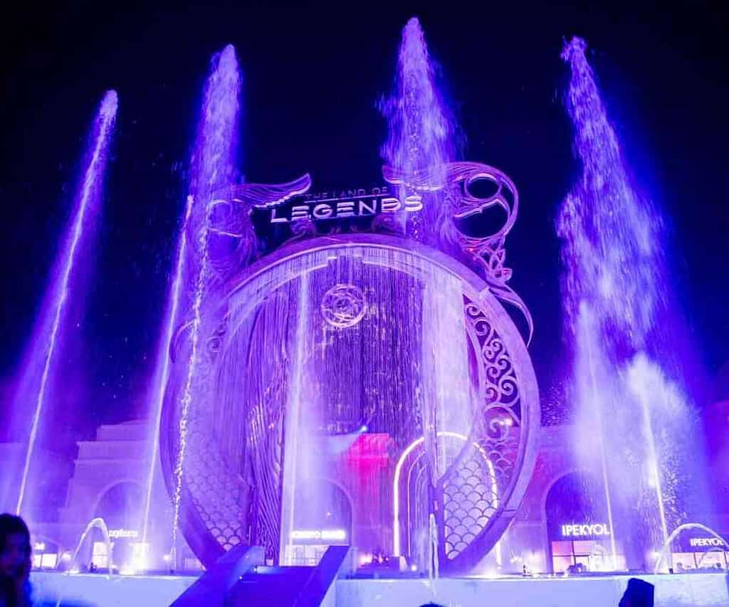 Synchronized water fountain show in front of the illuminated Fairy Tale Castle at Land of Legends in Belek