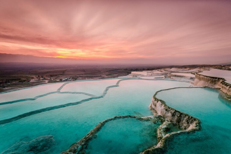 White Pamukkale travertine terraces with blue thermal pools in Denizli, Turkey
