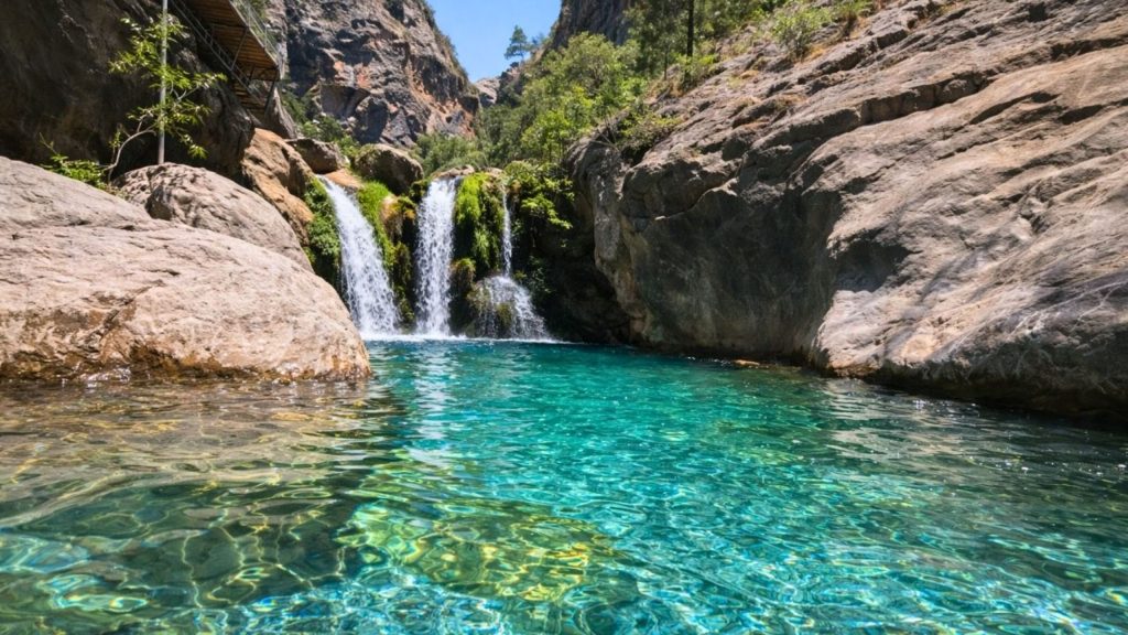 Sapadere Canyon waterfall flowing into a turquoise natural pool surrounded by limestone cliffs near Alanya