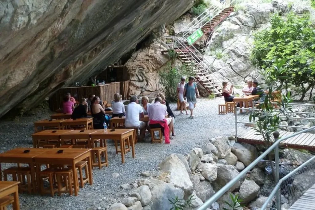 Travelers enjoying a traditional lunch beside the flowing mountain stream in Sapadere village near Alanya