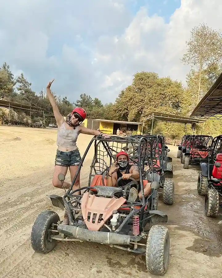 Professional guide giving a safety briefing and fitting helmets to guests before a Side buggy safari departure.