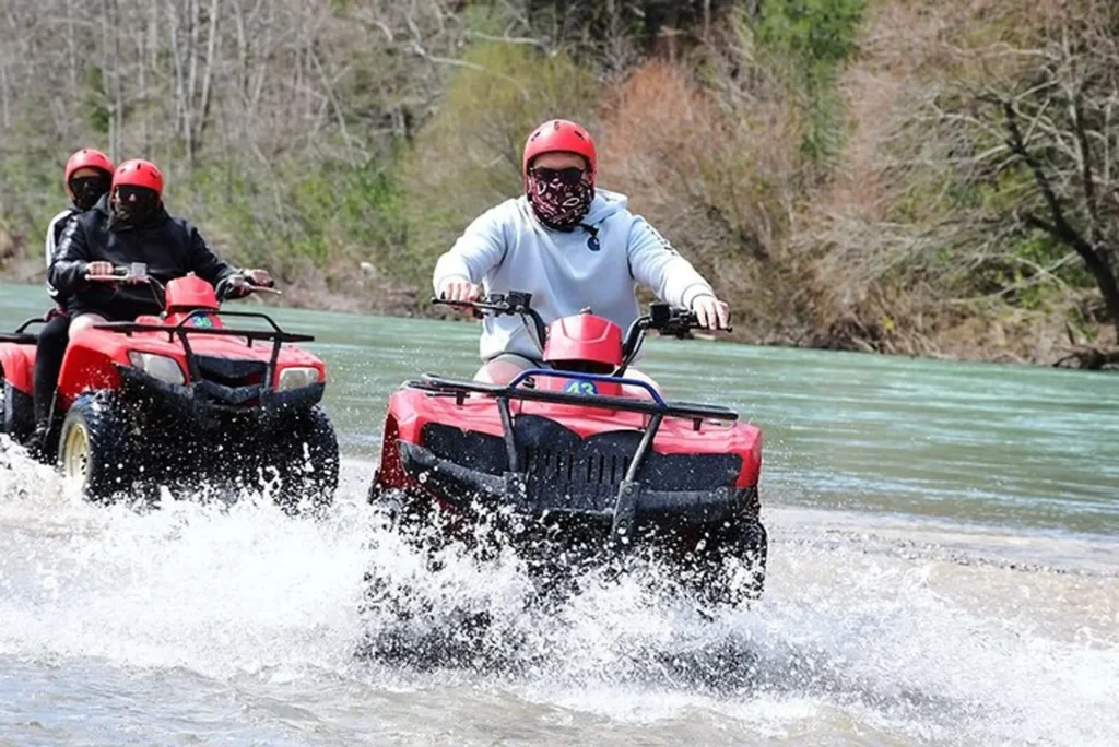 Tourist riding a quad bike on a dusty and muddy off-road trail in the Taurus Mountains near Köprülü Canyon during a Side adventure tour