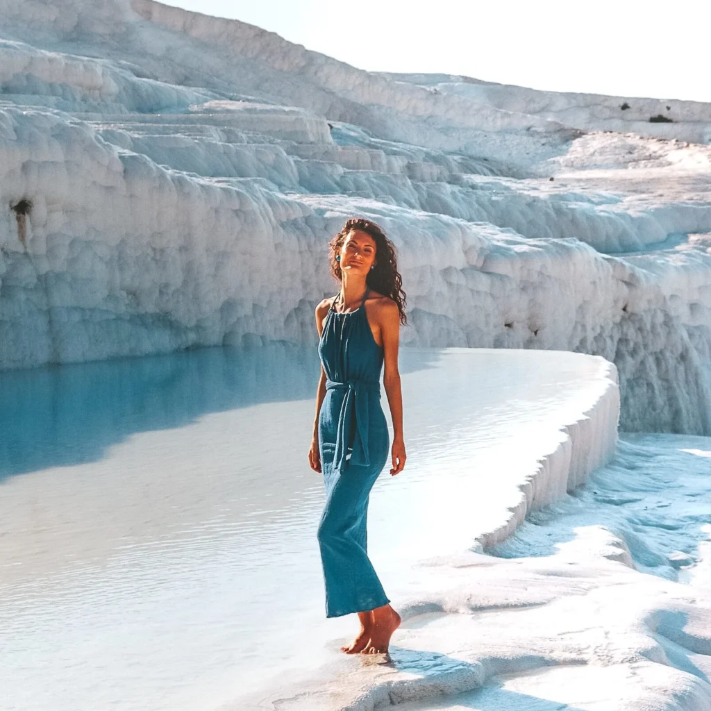 Visitors walking barefoot through thermal water on the white Pamukkale travertines in Turkey