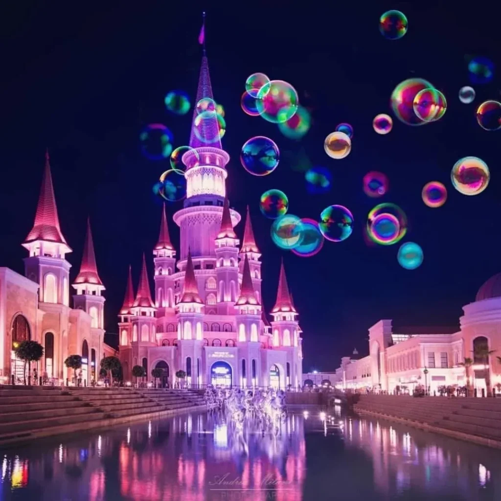 Visitors enjoying the illuminated Fairy Tale Castle during a Land of Legends night show excursion from Side, Turkey